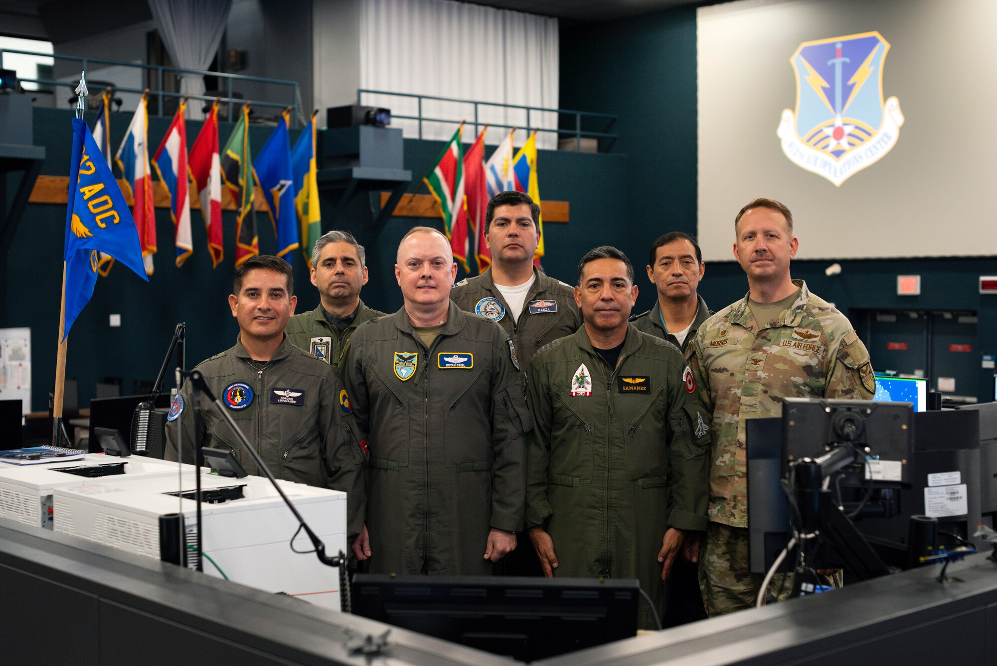Brig. Gen. John Creel, Air Forces Southern deputy commander, center-left, and Col. Donald Morris, 612th Air Operations Center (AOC) commander, far-right, pose for a group photo with Foreign Liaison Officers at Davis-Monthan Air Force Base, Arizona, March 14, 2025. The briefing marked phase two for the Liaison Officers from Argentina, Brazil, Chile, Colombia, Ecuador, and Peru, joining U.S. Air Force personnel at the 612th AOC, marking a significant milestone in coalition air power coordination. (U.S. Air Force photo by Tech. Sgt. Rachel Maxwell)
