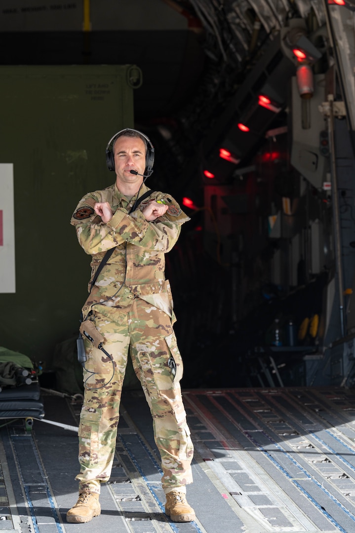 Capt. Jon Baran, a Reserve Citizen Airman assigned to the 433rd Airlift Wing, gives hand signals to other Airmen loading medical supplies and training equipment inside a C-17 Globemaster III during an aeromedical evacuation exercise onboard Naval Station (NAVSTA) Rota, Spain, March 10, 2025.