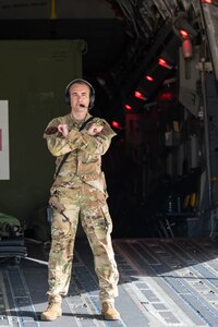 Capt. Jon Baran, a Reserve Citizen Airman assigned to the 433rd Airlift Wing, gives hand signals to other Airmen loading medical supplies and training equipment inside a C-17 Globemaster III during an aeromedical evacuation exercise onboard Naval Station (NAVSTA) Rota, Spain, March 10, 2025.