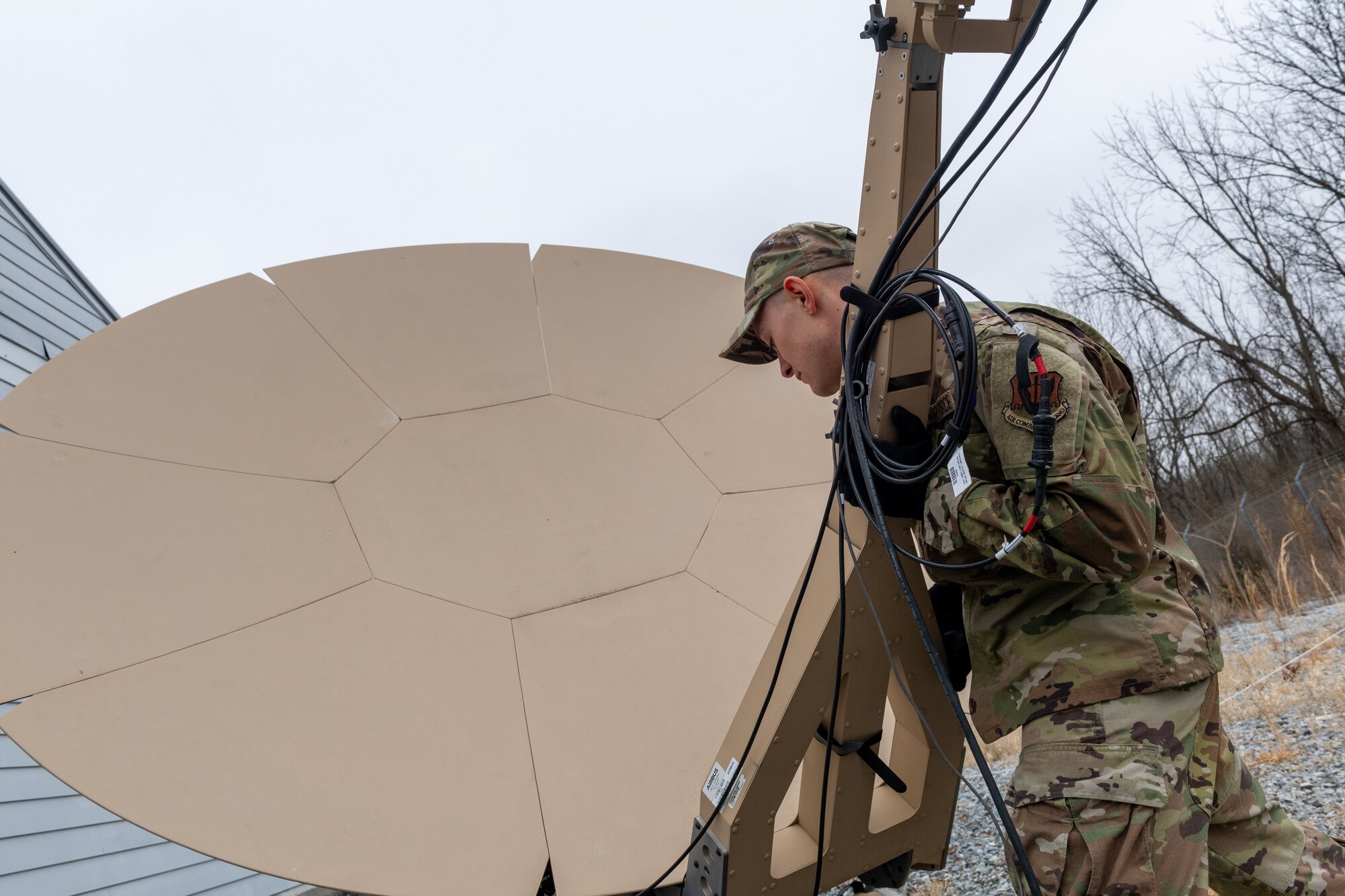 Airman 1st Class Elijah Allison, radio frequency transmission systems specialist with the 271st Combat Communications Squadron, repositions an Airbus Ranger 2400 satellite antenna due to projected severe weather, March 15, 2025.
