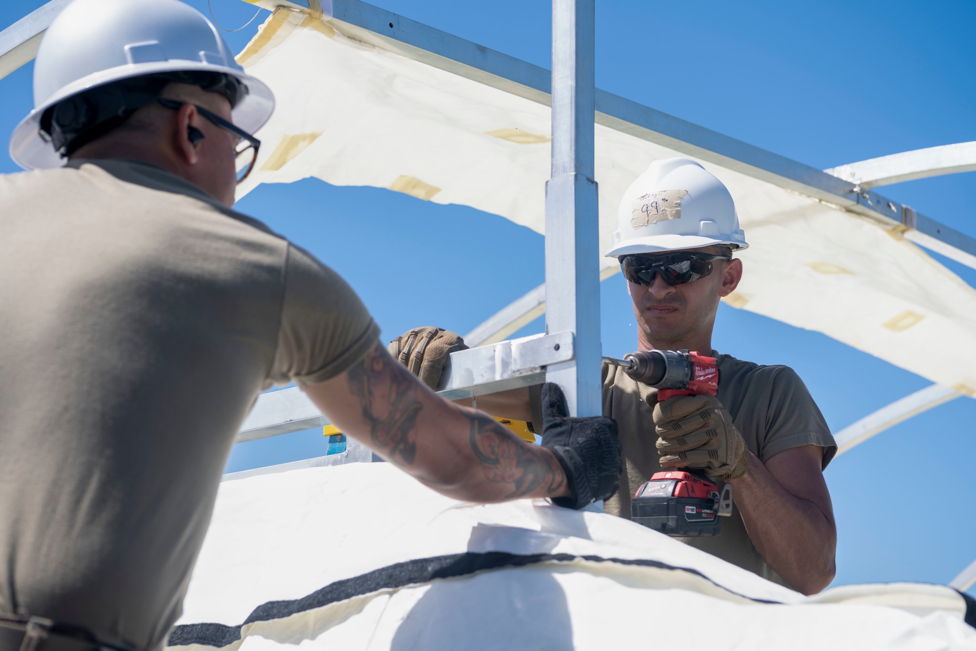 U.S. Air Force Senior Airman Angel Robles, a water and fuel systems maintenance journeyman with the 156th Civil Engineer Squadron, Puerto Rico Air National Guard, expands a frame pin hole during a Disaster Relief Beddown System build up at Muñiz Air National Guard Base, Carolina, Puerto Rico, Feb. 27, 2025. The 156th CES Airmen assembled the DRBS, a system with the capacity to shelter 150 people in case of a disaster as a training opportunity in preparation for the March regularly scheduled drill. (U.S. Air National Guard photo by Master Sgt. Rafael D. Rosa)