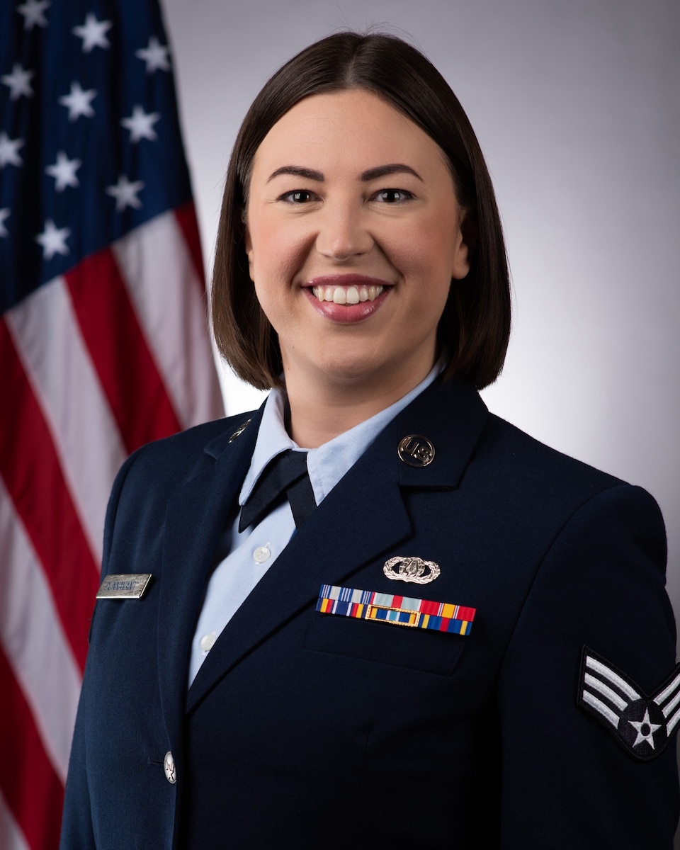 Official Photo of SrA Jessie Dunnavant, vocalist with the USAF Band of the Pacific-Asia, Yokota AB, Japan.  SrA Dunnavant is wearing blue service dress in front of the American flag.