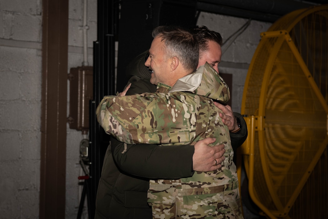 A U.S. Air Force member hugs the Area Mayor of Speicher.