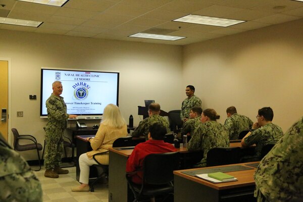 Naval Health Clinic Lemoore's Deputy Director, Capt. Mathew Loe (left front), opened the clinic's Defense Medical Human Resources System Internet (DMHRSi)  timekeepers and approvers training conducted by Hospital Corpsman 2nd Class Rigoberto Hernandez (right front) on March 12.