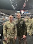 Male U.S. Army Soldier in AGSU poses with male U.S. Army Soldier in ACU on the court of a basketball stadium