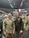 Male U.S. Army Soldier in AGSU poses with male U.S. Army Soldier in ACU on the court of a basketball stadium