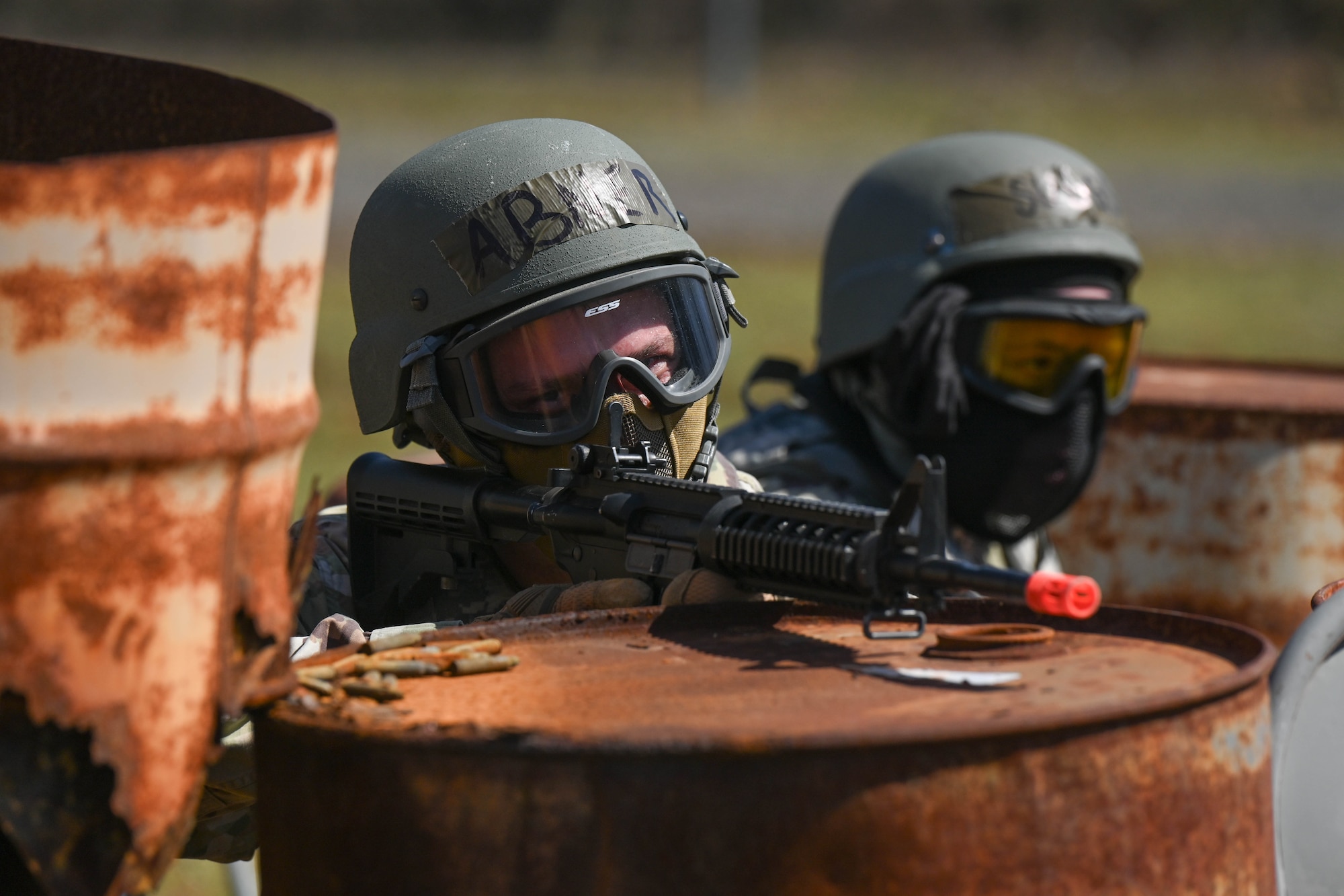 Two men behind barrels.