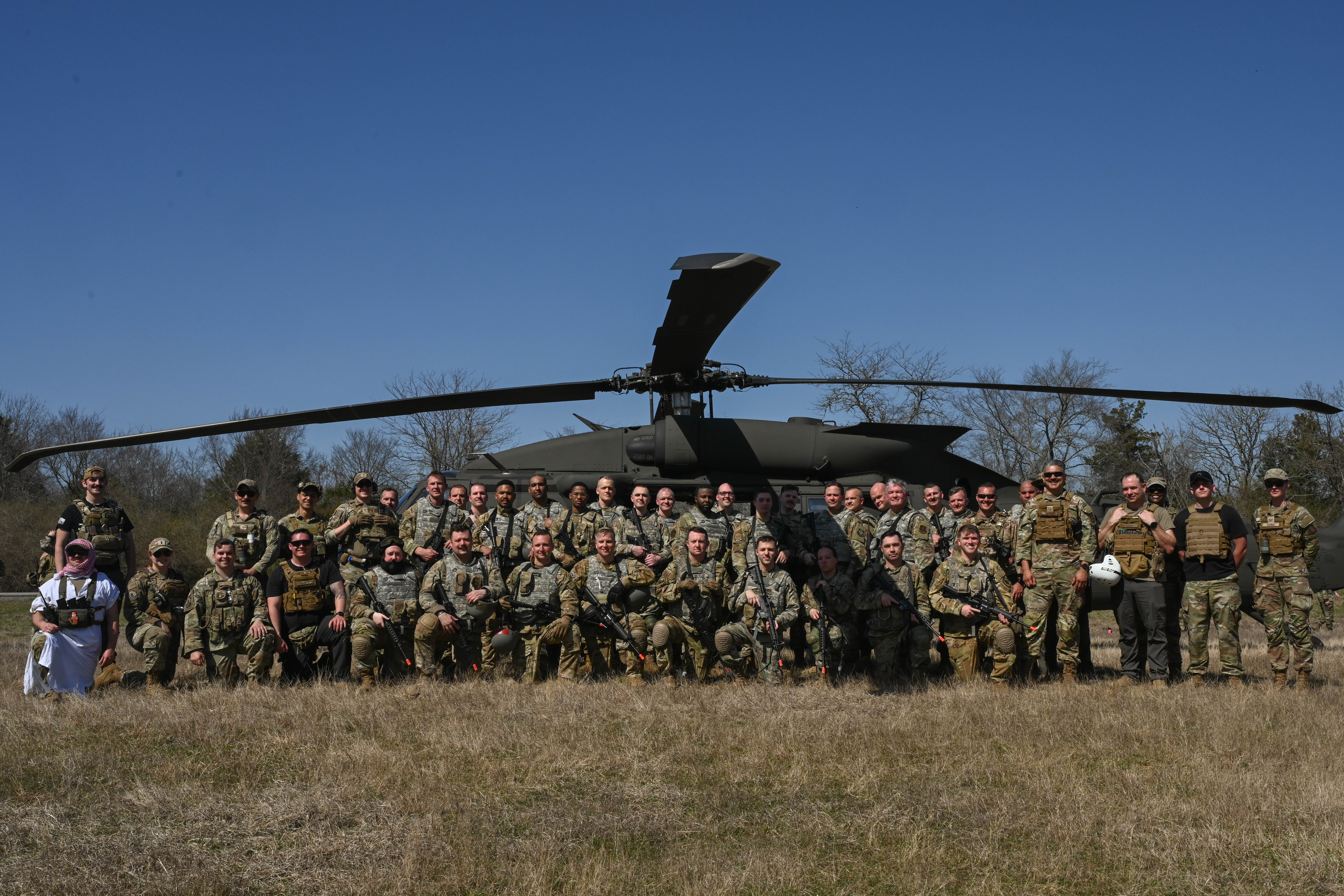 Group photo in front of helicopter.