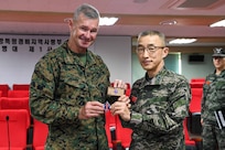 U.S. Marine Corps Maj. Gen. Thomas B. Savage, left, the commanding general of 1st Marine Division, gifts a 1st MARDIV coin and patch to Republic of Korea Marine Corps Maj. Gen. Lee Ho Jong, the commanding general of 1st Marine Division, ROK Marine Corps, during a meeting in Pohang, South Korea, March 7, 2025.
