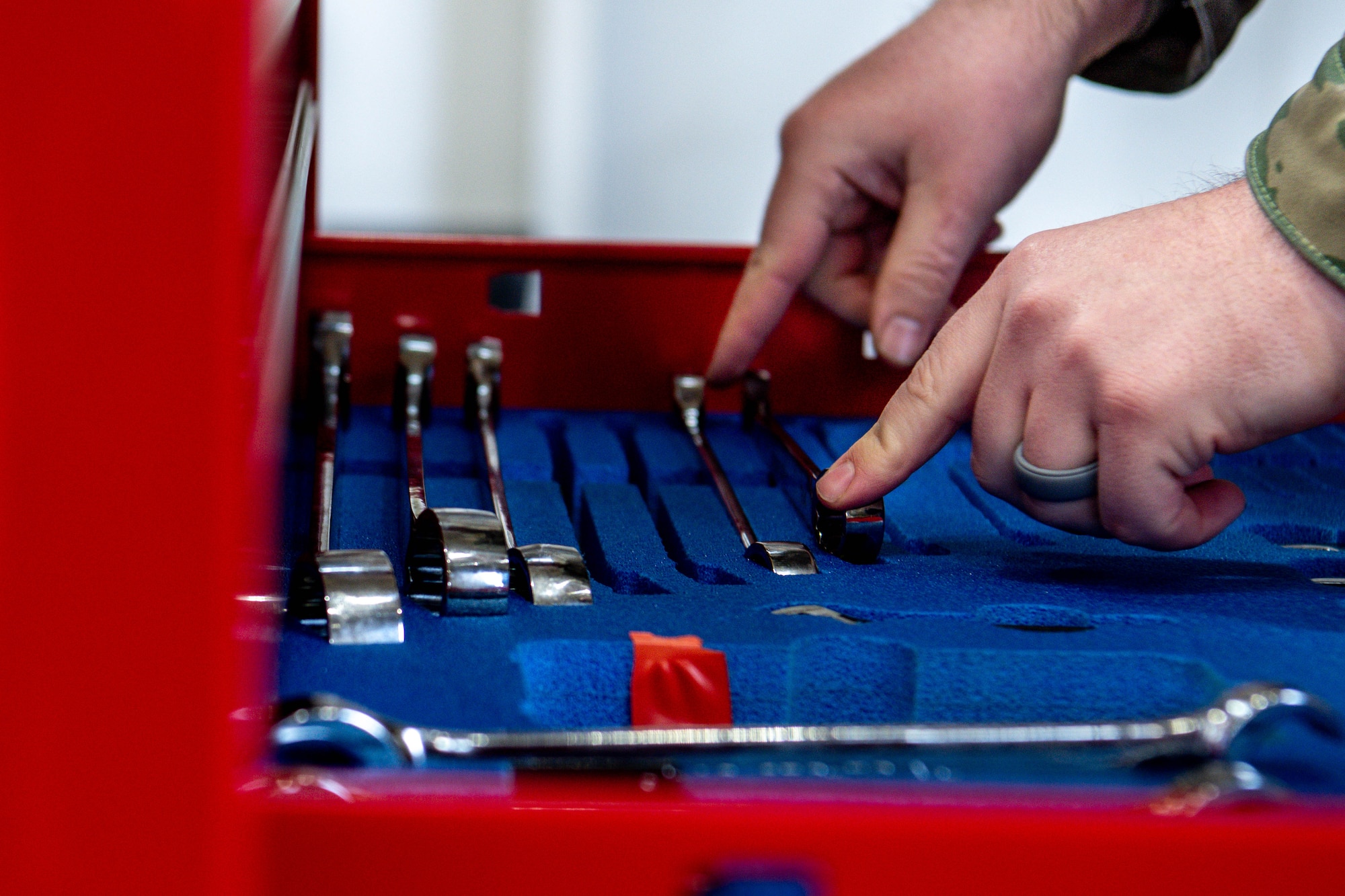 An Airman assigned to the 374th Maintenance Group places tools back into a tool chest.