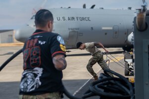 U.S. Air Force Senior Airman Daiquan Baskin, 374th Aircraft Maintenance Squadron flying crew chief, pulls aircraft chocks.