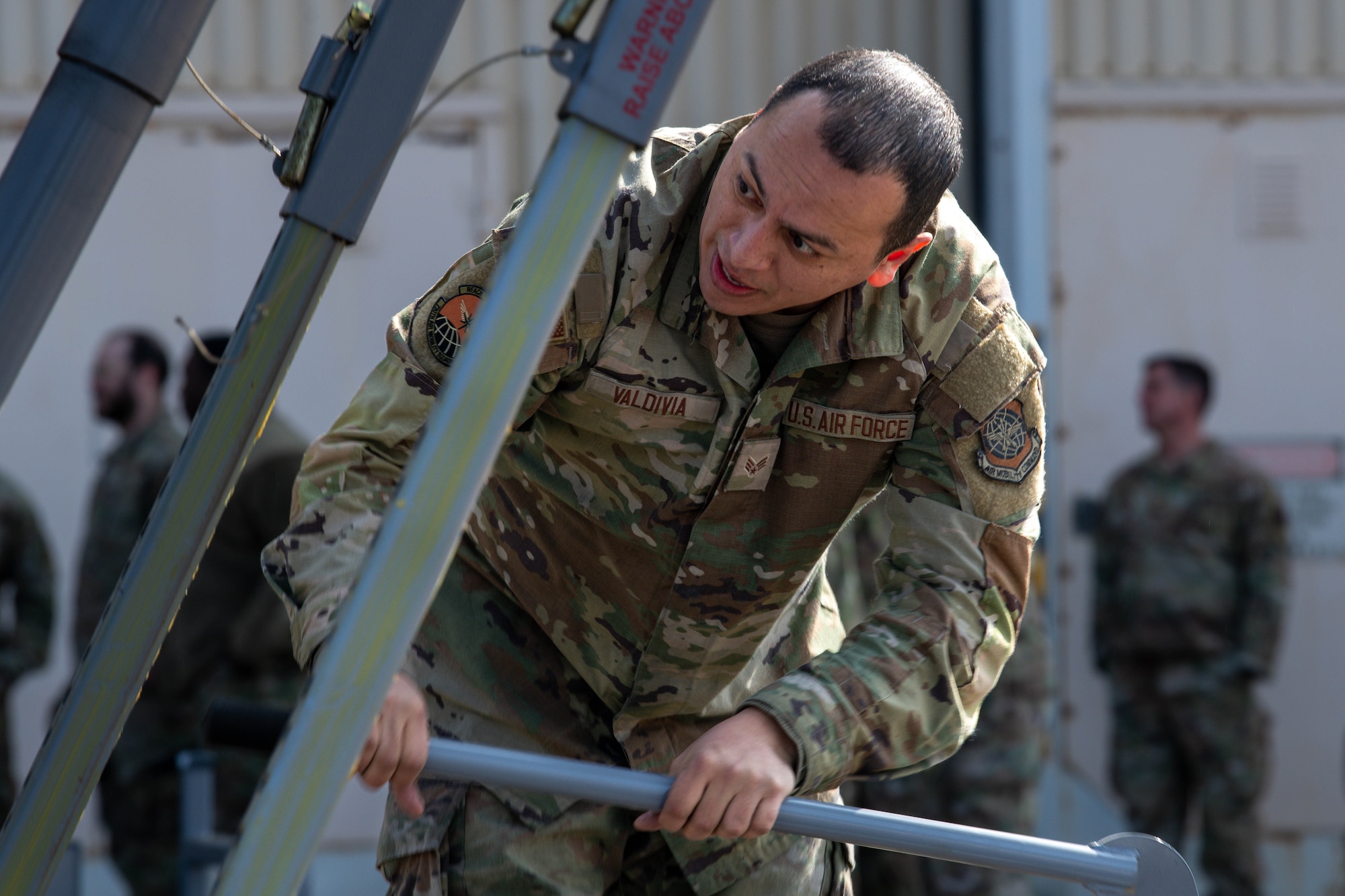 U.S. Air Force Senior Airman Jesse Valdivia, 730th Air Mobility Squadron crew chief, raises a stair ladder.