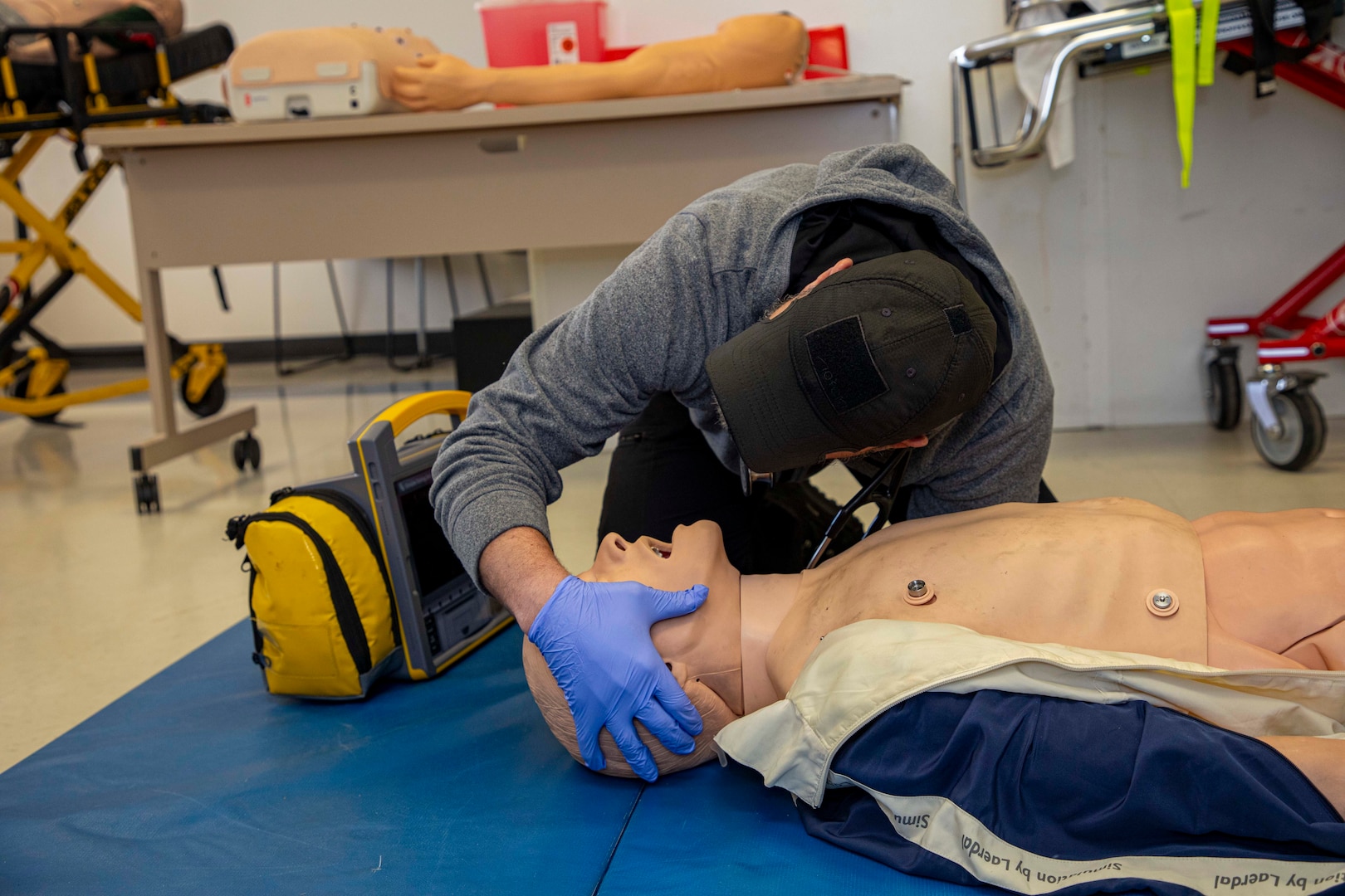 250303-N-KC192-1140 SPRING LAKE, N.C. (Mar. 3, 2025) - Hospital Corpsman 1st Class Axel Narvaez, the regional training officer assigned to Naval Medical Forces Atlantic (NMFL),  checks the airway breathing of a simulated patient during a training scenario during a paramedic training scenario at Fayetteville Technical Community College, Mar. 3, 2025. The primary purpose of the 20-week joint military paramedic course at Fayetteville Technical Community College in Spring Lake, North Carolina is to expand the skills of service members, and increase survivability of those in harm’s way. Navy Medicine is enhancing Expeditionary Medical Unit (EXMED) capabilities by equipping Hospital Corpsmen with advanced trauma and pre-hospital care skills through an accelerated paramedic training program. This intensive five-month course ensures corpsmen are prepared to deliver life-sustaining care in austere environments, strengthening the Navy’s ability to support warfighters in operational settings worldwide. (U.S. Navy photo by Mass Communication Specialist 2nd Class Levi Decker)