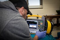 250303-N-KC192-1107 SPRING LAKE, N.C. (Mar. 3, 2025) - Hospital Corpsman 1st Class Axel Narvaez, the regional training officer assigned to Naval Medical Forces Atlantic (NMFL),  prepares a simulation defibrillator during a training scenario during a paramedic training scenario at Fayetteville Technical Community College, Mar. 3, 2025. The primary purpose of the 20-week joint military paramedic course at Fayetteville Technical Community College in Spring Lake, North Carolina is to expand the skills of service members, and increase survivability of those in harm’s way. Navy Medicine is enhancing Expeditionary Medical Unit (EXMED) capabilities by equipping Hospital Corpsmen with advanced trauma and pre-hospital care skills through an accelerated paramedic training program. This intensive five-month course ensures corpsmen are prepared to deliver life-sustaining care in austere environments, strengthening the Navy’s ability to support warfighters in operational settings worldwide. (U.S. Navy photo by Mass Communication Specialist 2nd Class Levi Decker)