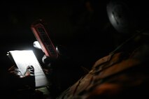 handheld field manual held by Airman
