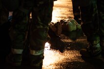 practice dummy lays on the ground amidst service members in protective gear
