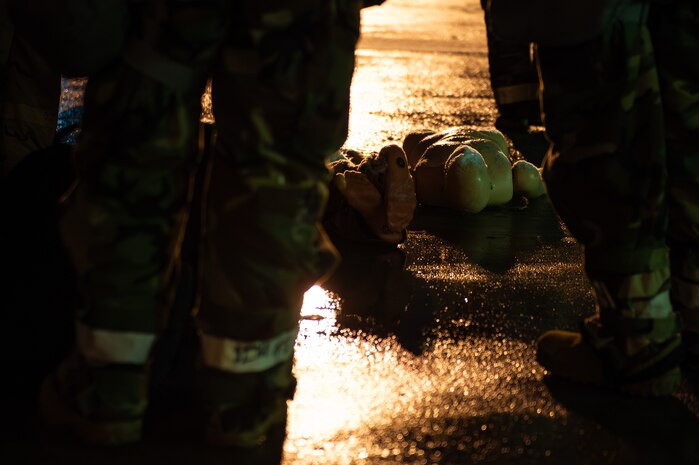 practice dummy lays on the ground amidst service members in protective gear