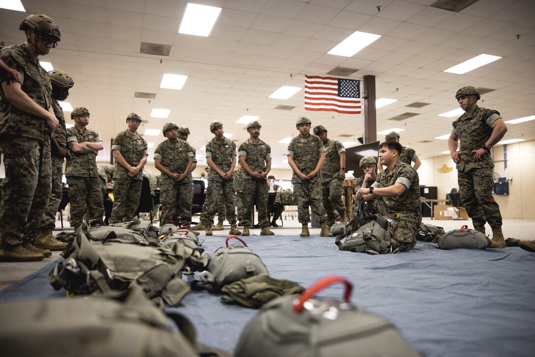 A U.S. Marine with 2nd Distribution Support Battalion, Combat Logistics Regiment 2, 2nd Marine Logistics Group, briefs Marines on proper parachute packing techniques in preparation for air delivery operations and static line training on Camp Lejeune, North Carolina, March 12, 2025. 2nd DSB conducted this training to increase parachuting and jumpmaster proficiency while enhancing the tactical and operational readiness of its Marines for future real-world operations. (U.S. Marine Corps photo by Cpl. Meshaq Hylton)