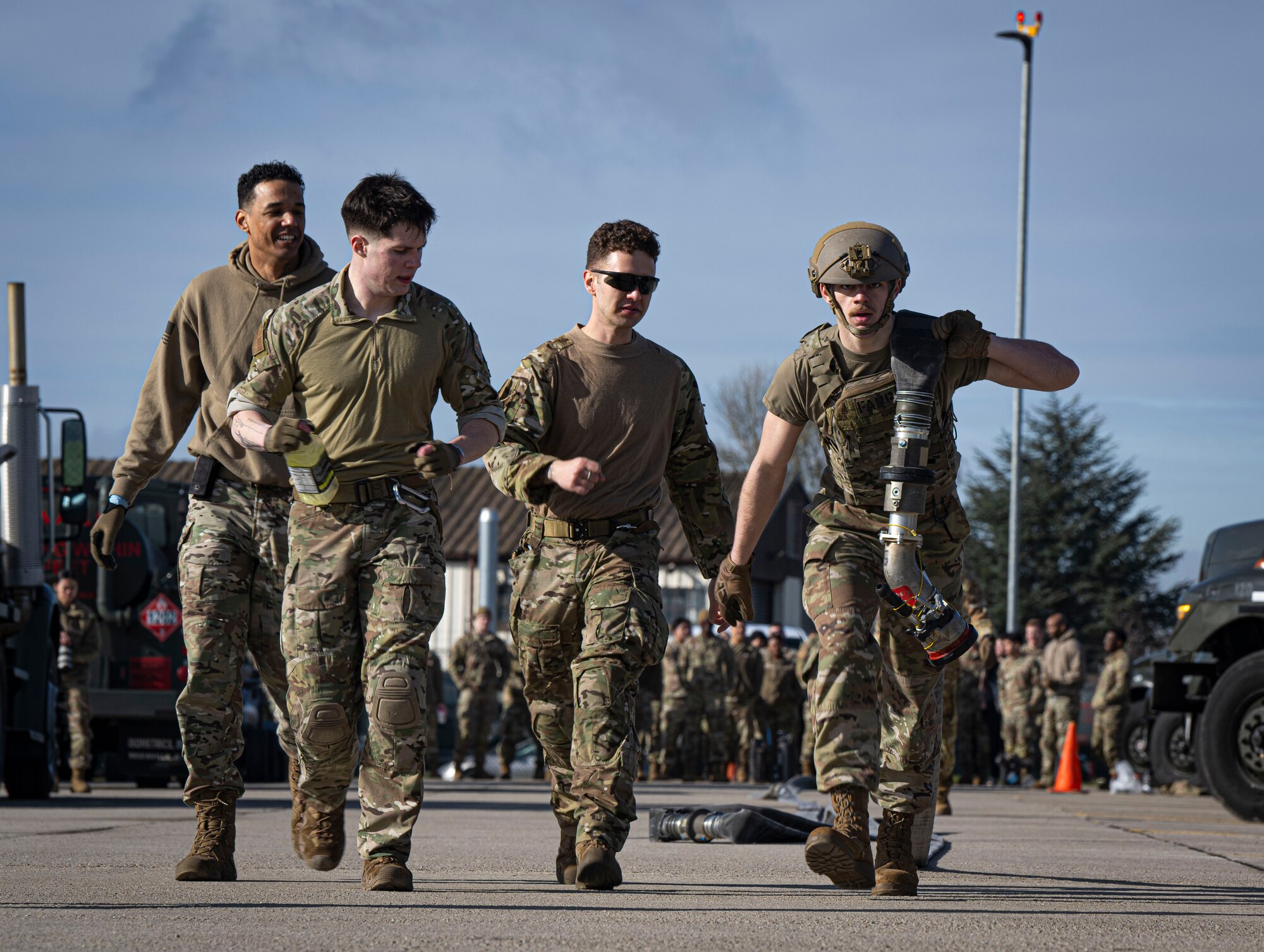 U.S. Air Force Airman 1st Class William Hall, right, 100th Logistics Readiness Squadron fuels distribution apprentice, hauls a fuel hose during a forward area refueling point team tryout at RAF Mildenhall, England, March 14, 2025.