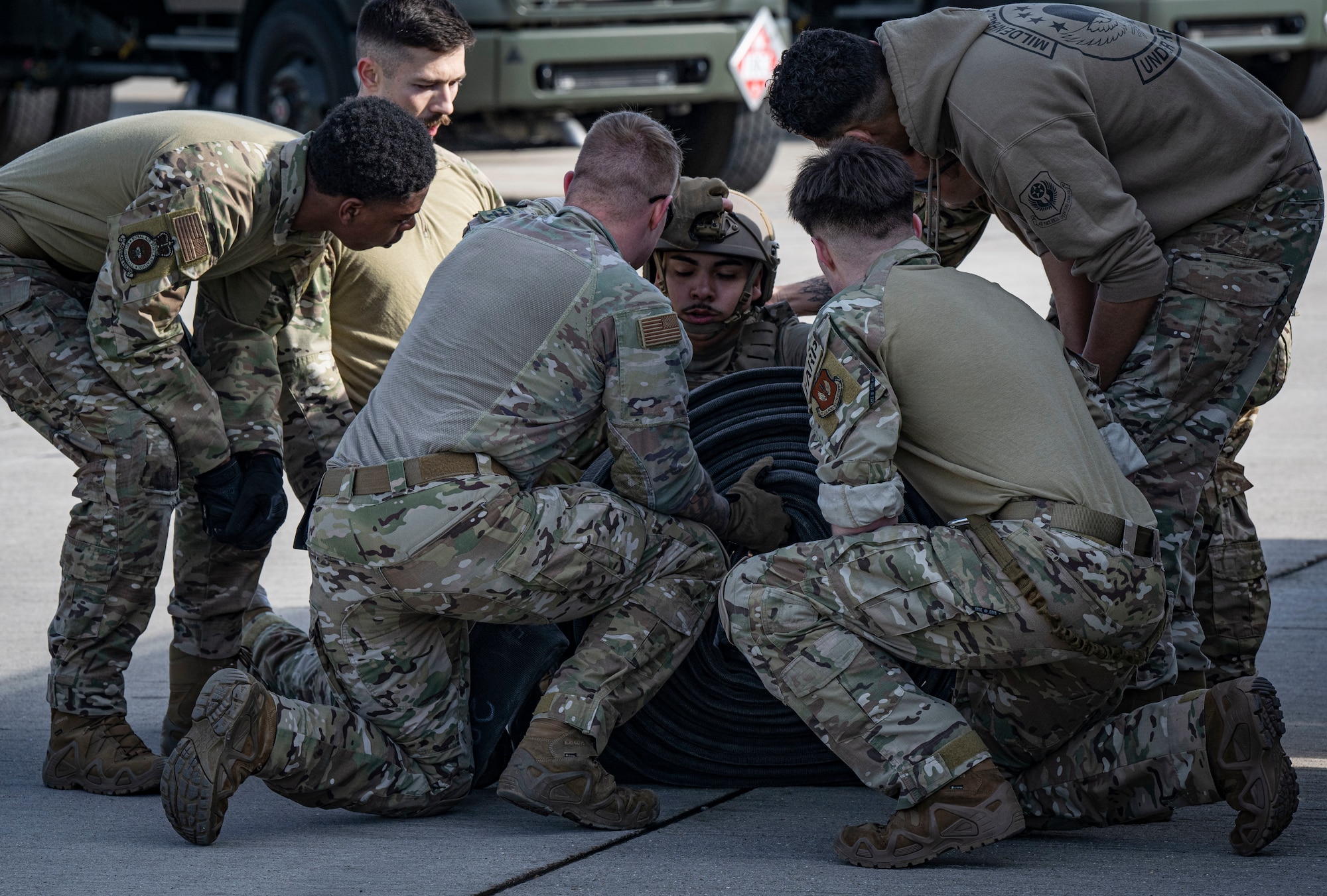 U.S. Air Force Airman 1st Class Sydney Herrera, center right, 100th Logistics Readiness Squadron fuels distribution operator, catches his breath during his forward area refueling point team tryout at RAF Mildenhall, England, March 14, 2025.