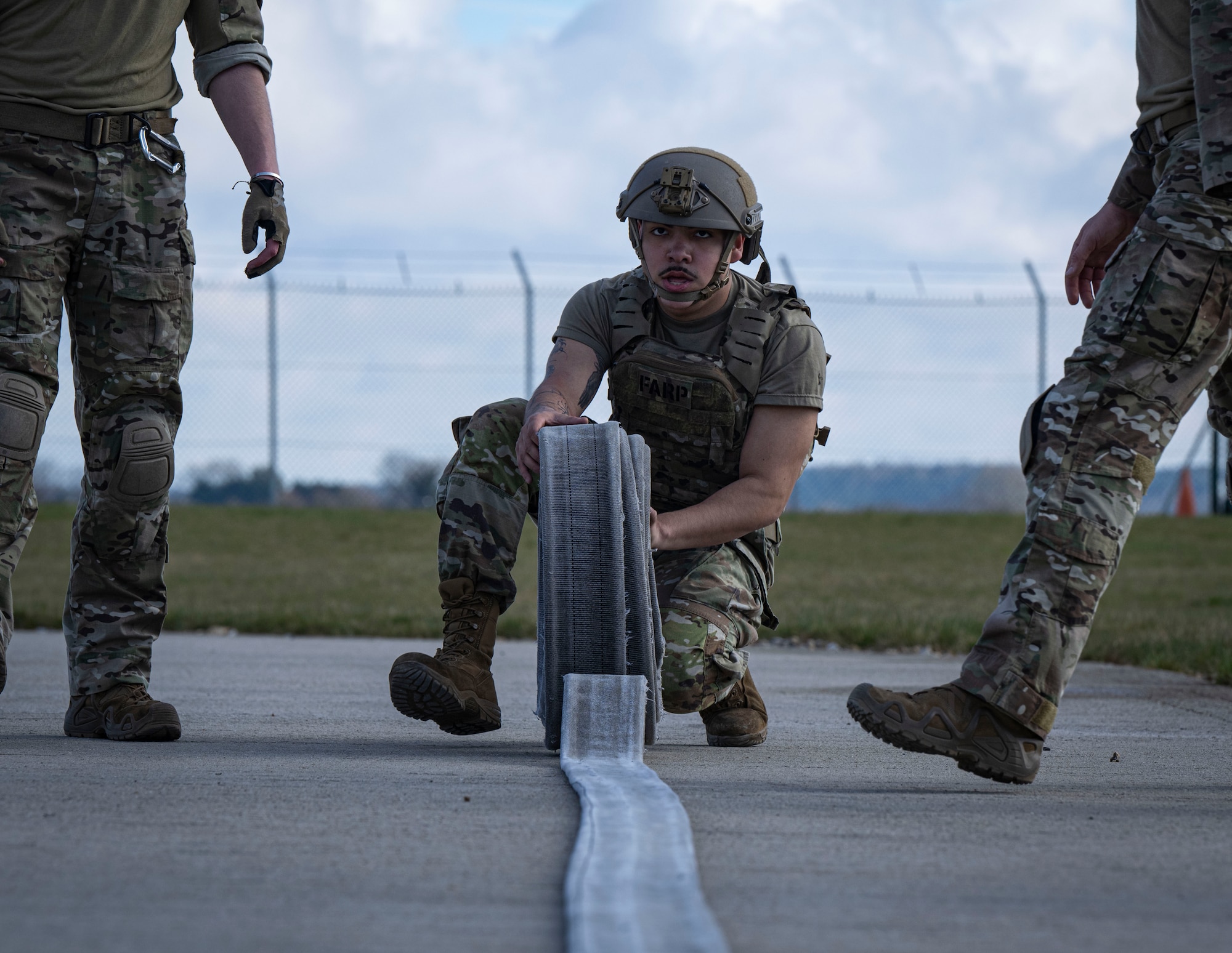 U.S. Air Force Airman 1st Class Sydney Herrera, 100th Logistics Readiness Squadron fuels distribution operator, rolls a fuel hose during his forward area refueling point team tryout at RAF Mildenhall, England, March 14, 2025.