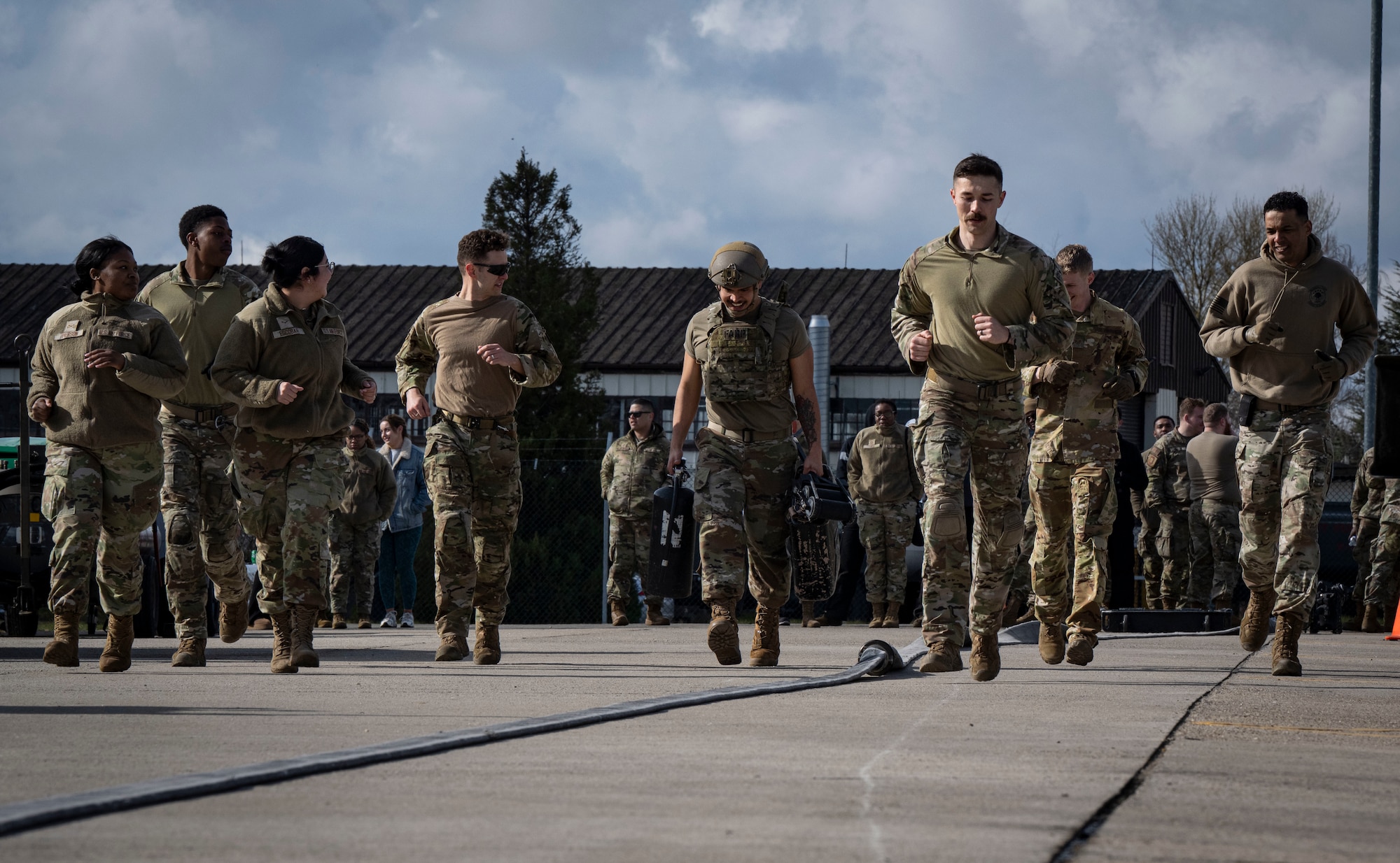 U.S. Airmen run as a group with a participant in a forward area refueling point team tryout at RAF Mildenhall, England, March 14, 2025.