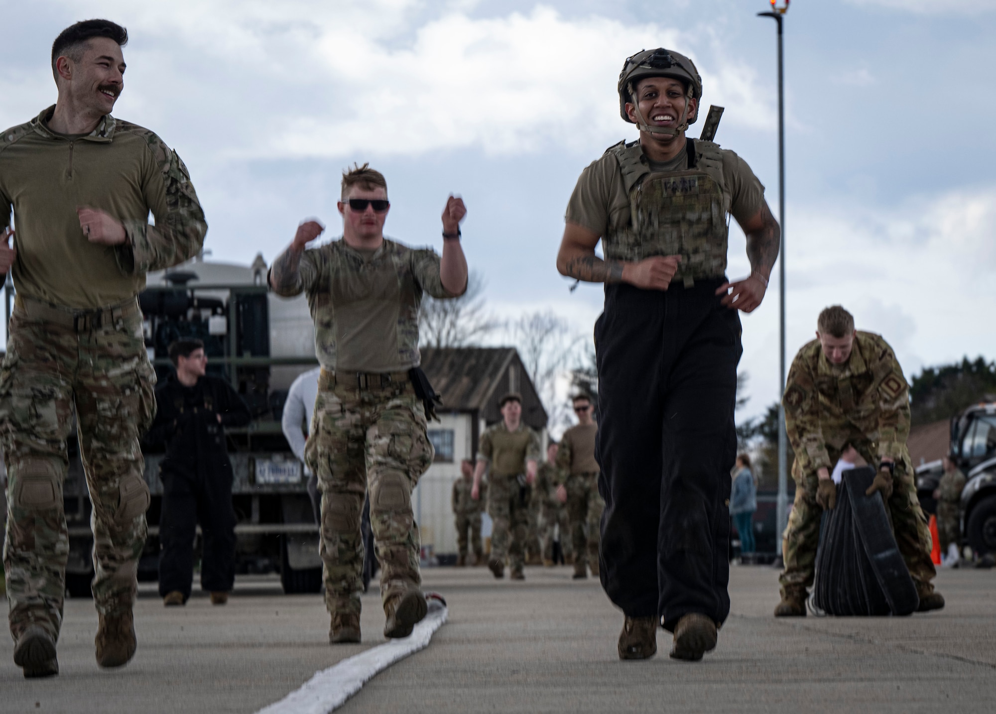 U.S. Air Force Staff Sgt. Rasean Chong, right, 100th Logistics Readiness Squadron refueler and fire truck maintenance noncommissioned officer in charge, runs during his forward area refueling point team tryout at RAF Mildenhall, England, March 14, 2025.