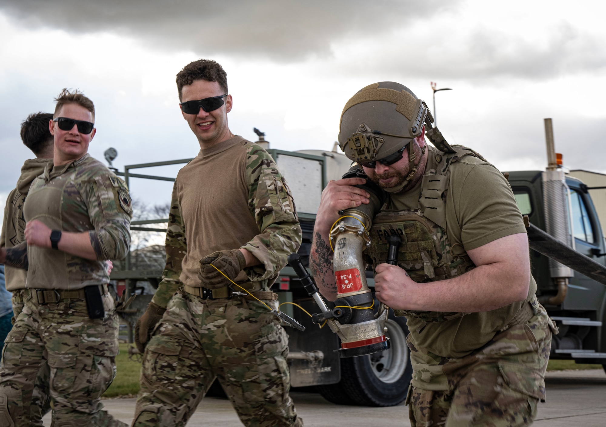 U.S. Air Force Staff Sgt. Marty Ward, right, 100th Logistics Readiness Squadron vehicle maintenance flight training leader and quality assurance evaluator, hauls fuel hose during his forward area refueling point team tryout at RAF Mildenhall, England, March 14, 2025.