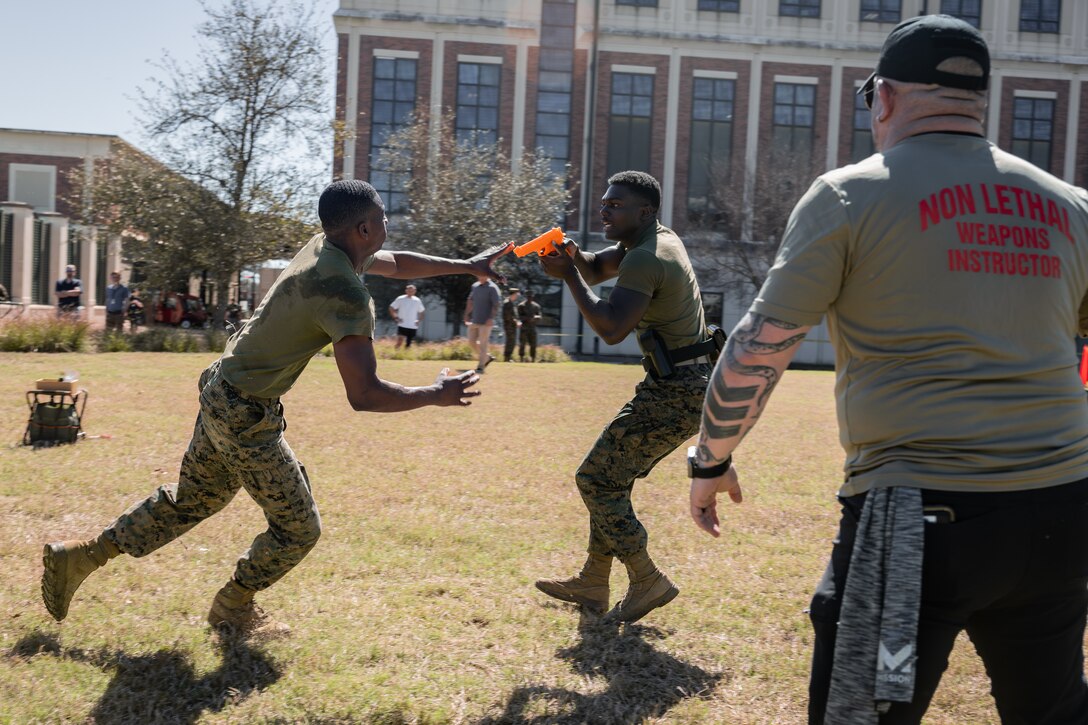 U.S. Marine Corps Lance Cpl. Edward Spears, combat videographer, Headquarters Battalion, Marine Forces Reserve, commands a simulated enemy to stop during Security Augmentation Force training, Marine Corps Support Facility, New Orleans, Feb. 26, 2025. Marines experience the effects of pepper spray to learn when to use it appropriately as a method of de-escalation, and to understand how to defend themselves or apprehend suspects. (U.S. Marine Corps photo by Lance Cpl. Van Hoang)