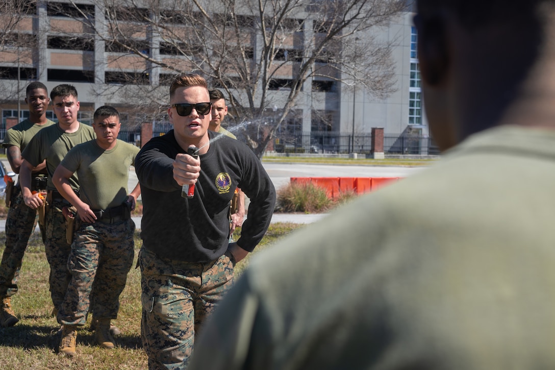 U.S. Marine Corps Sgt. John Zostant, military police officer, Headquarters Battalion, Marine Forces Reserve, pepper sprays a Marine during Security Augmentation Force training, Marine Corps Support Facility, New Orleans, Feb. 26, 2025. Marines experience the effects of pepper spray to learn when to use it appropriately as a method of de-escalation, and to understand how to defend themselves or apprehend suspects. (U.S. Marine Corps photo by Lance Cpl. Van Hoang)