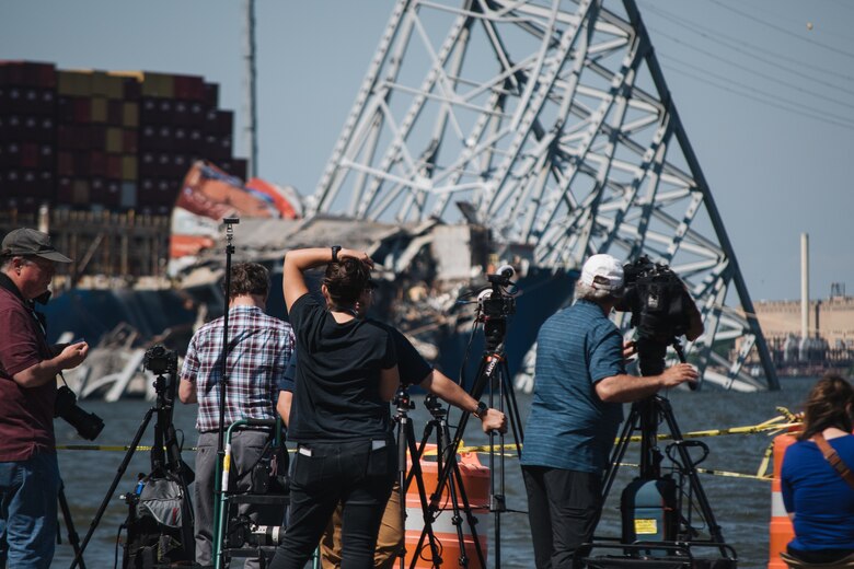 people in front of collapsed bridge