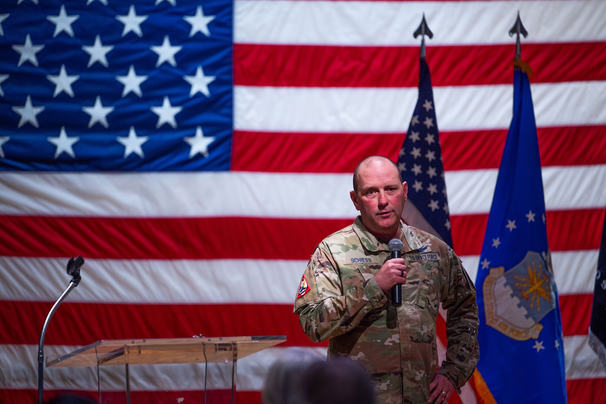 A man in uniform talks to a crowd of people.