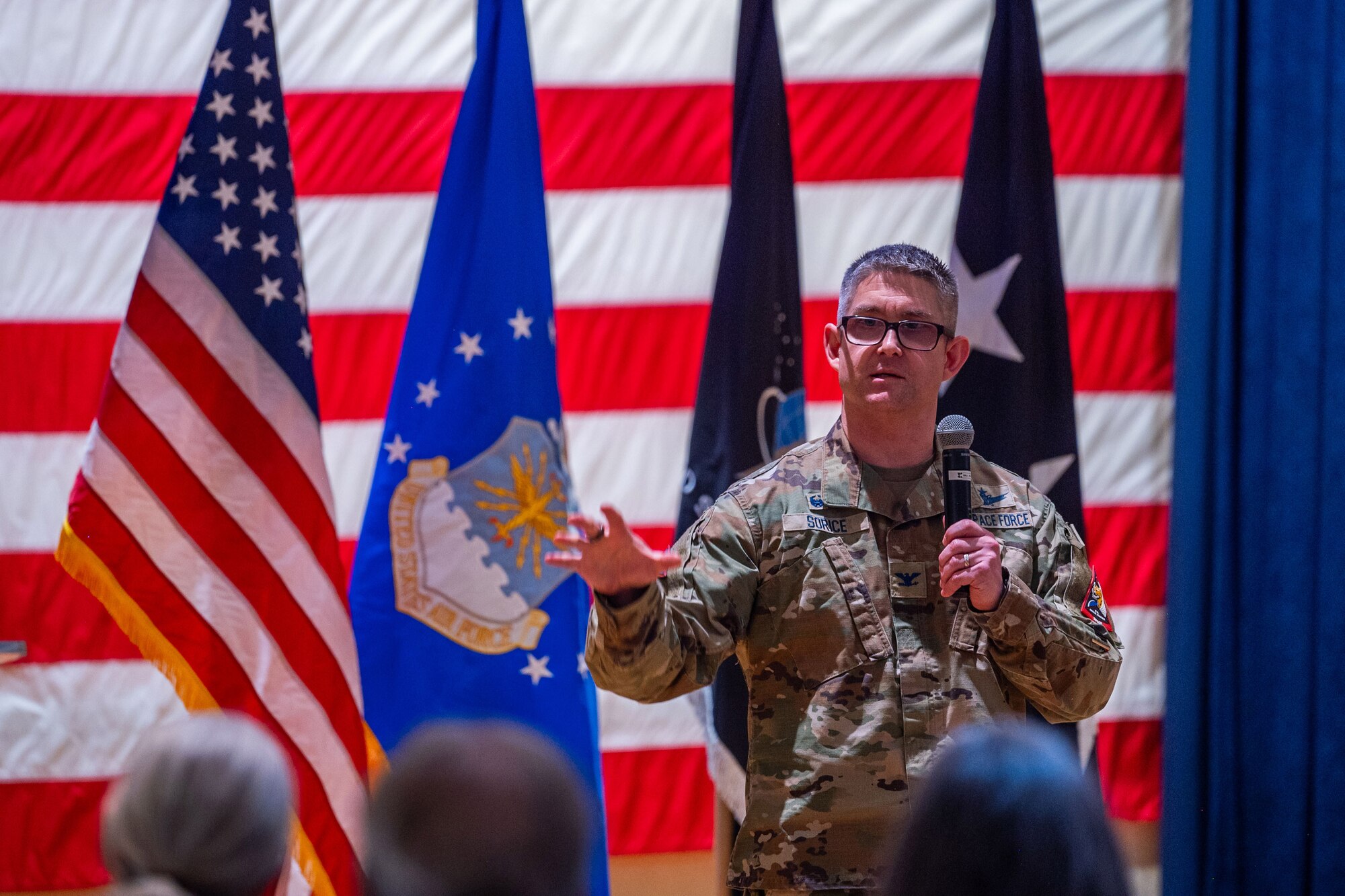 A man in uniform talks to a crowd of people.