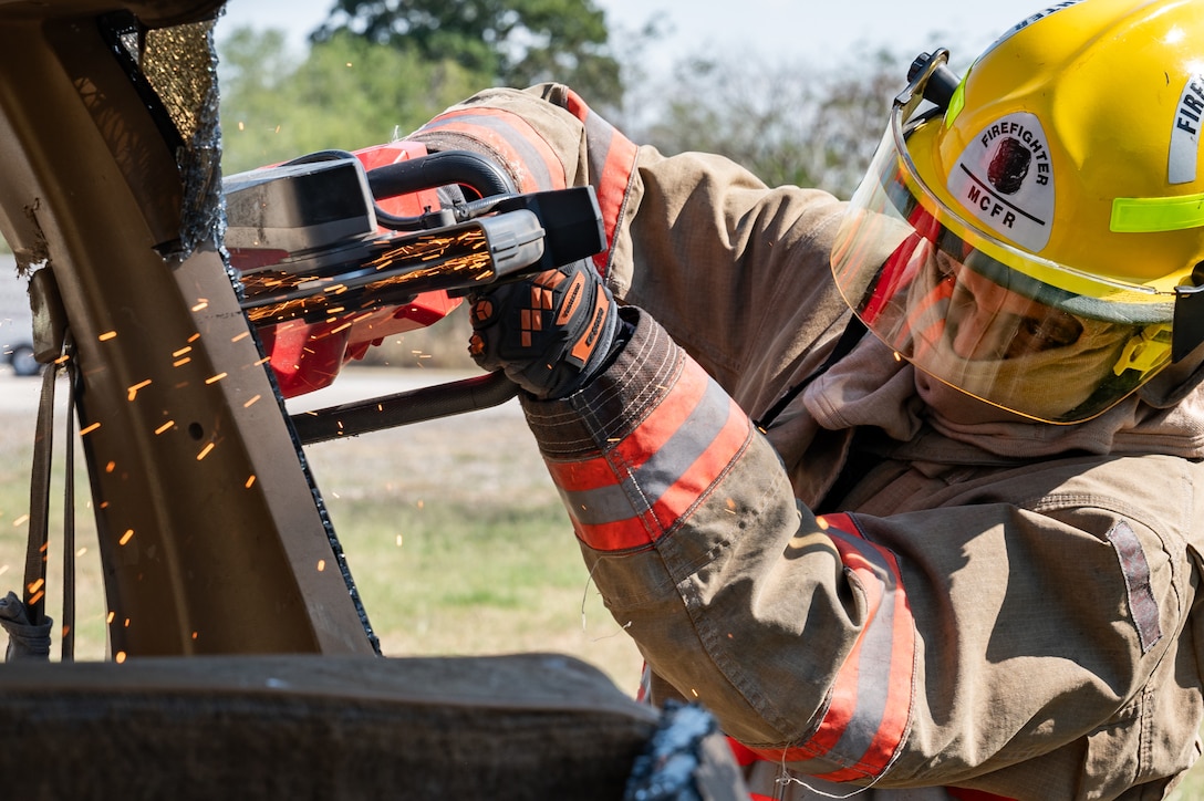 A local Honduran firefighter cuts a door frame of a car during a hazmat exercise at Soto Cano Air Base, Honduras, March 14, 2025.