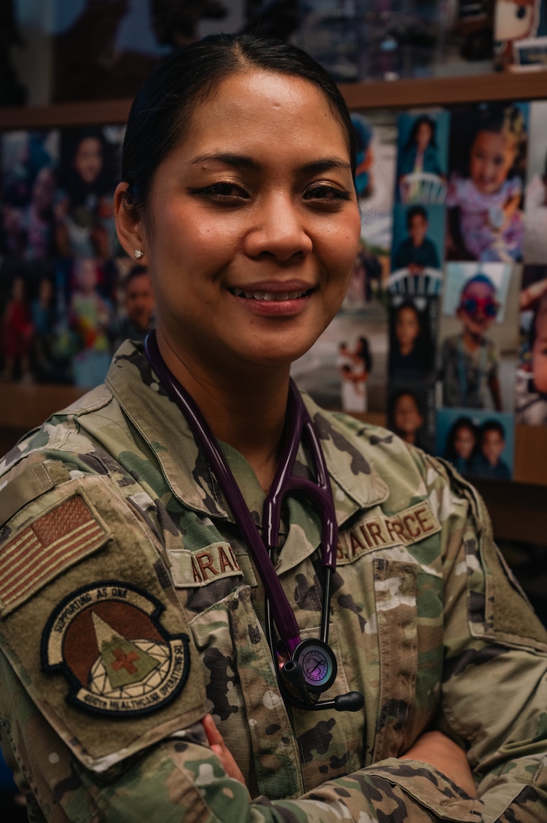 woman smiling in front of family photos