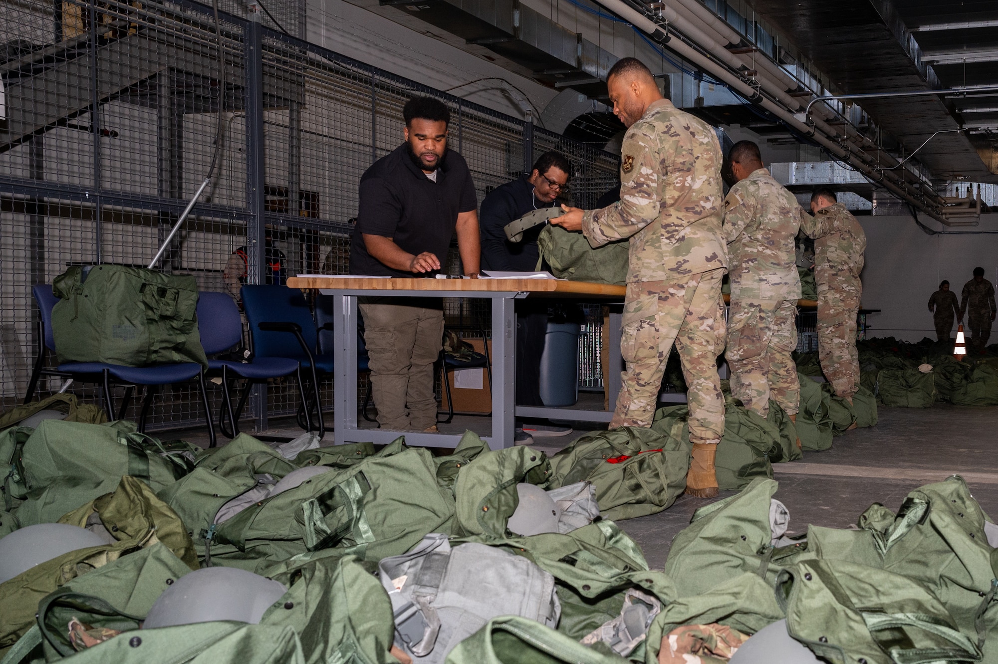 Members of the 11th Wing are issued individual protective equipment by 11th Logistic Readiness Squadron staff for a pre-deployment function line during an exercise on Joint Base Anacostia-Bolling, Washington, D.C., March 12, 2025. The 11th WG regularly conducts exercises to ensure constant readiness, streamline lethality and maintain strategic advantage. (U.S. Air Force photo by Hayden Hallman)