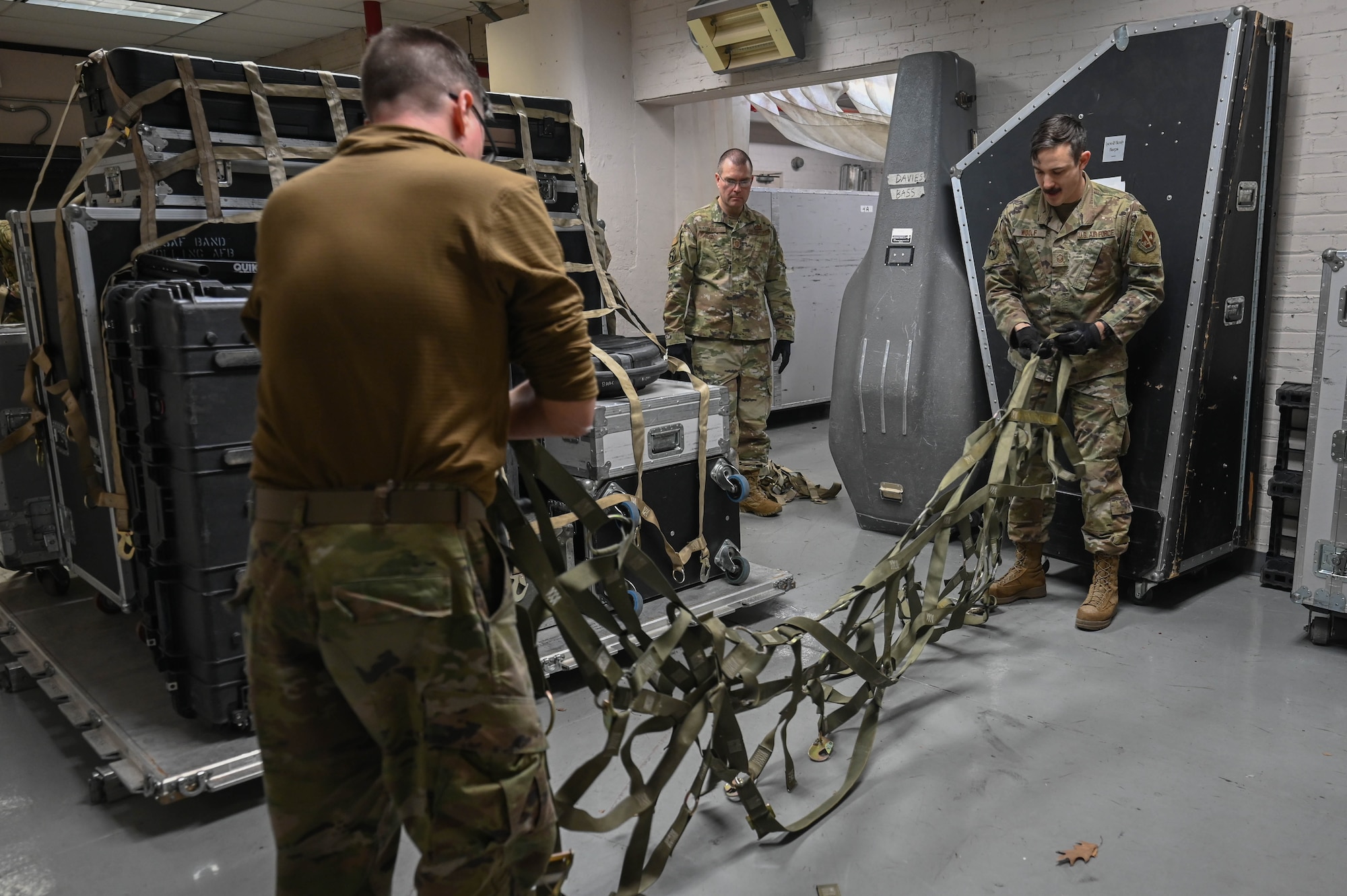 Members of the U.S. Air Force Band lay out a cargo net to prepare for loading during a readiness exercise at Joint Base Anacostia-Bolling, Washington, D.C., March 11, 2025. The exercise focused on how mission ready Airmen can adapt, anticipate and react to changes in a fast-paced operating environment. (U.S. Air Force photo by Airman 1st Class Geneva Nguyen)