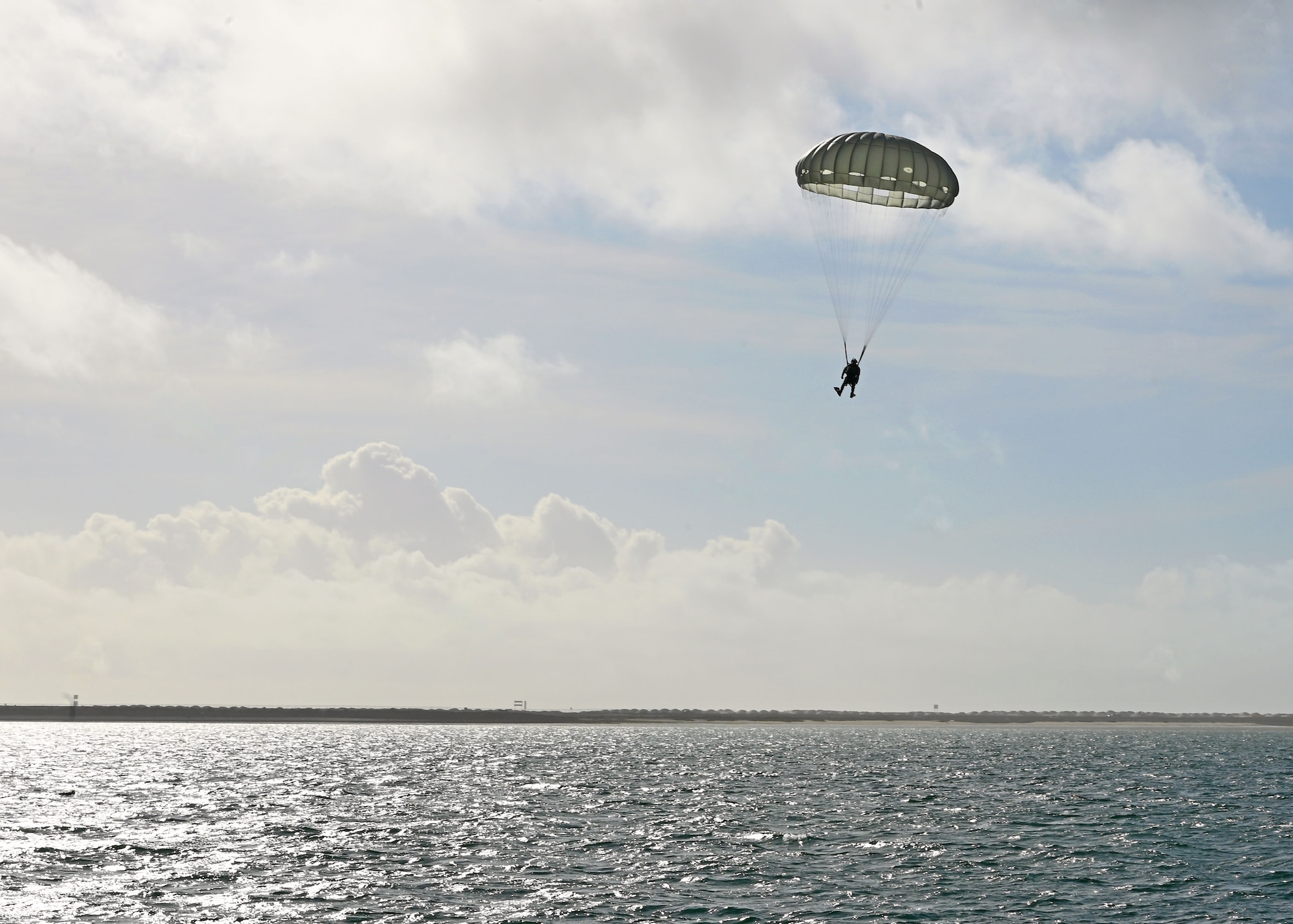 A U.S. Airman assigned to the 38th Rescue Squadron airdrops into an open water scenario for Exercise Bamboo Eagle 25-1, in the San Diego Bay, California, Feb. 14, 2025. The 414th Combat Training Squadron Detachment 1 led this large-scale, high-intensity combat training operation, where they simulated real-world combat environments that allowed participating forces to practice and improve their tactics, techniques, and procedures in a safe, controlled environment. (U.S. Air Force photo by Staff Sgt. Abbey Rieves)