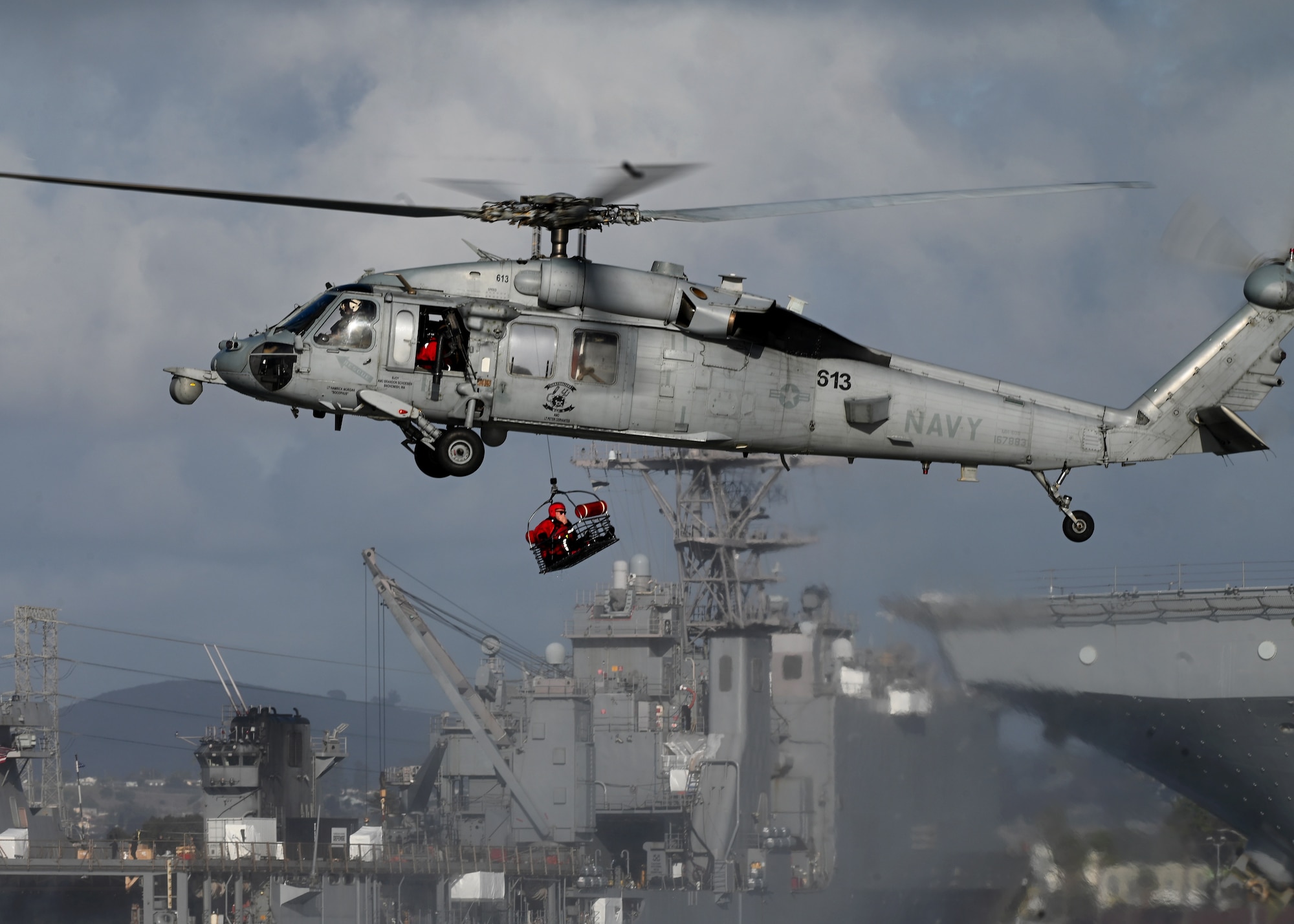 A U.S. Navy MH-60S SeaHawk helicopter assigned to the Helicopter Sea Combat Squadron 8 extracts an isolated personnel during Exercise Bamboo Eagle 25-1, from the San Diego Bay, California, on Feb. 14, 2025. This training scenario was designed by the 414th Combat Training Squadron Detachment 1 to strengthen cooperation among joint and allied forces and sharpen their combat readiness to respond quickly to new threats. (U.S. Air Force photo by Staff Sgt. Abbey Rieves)