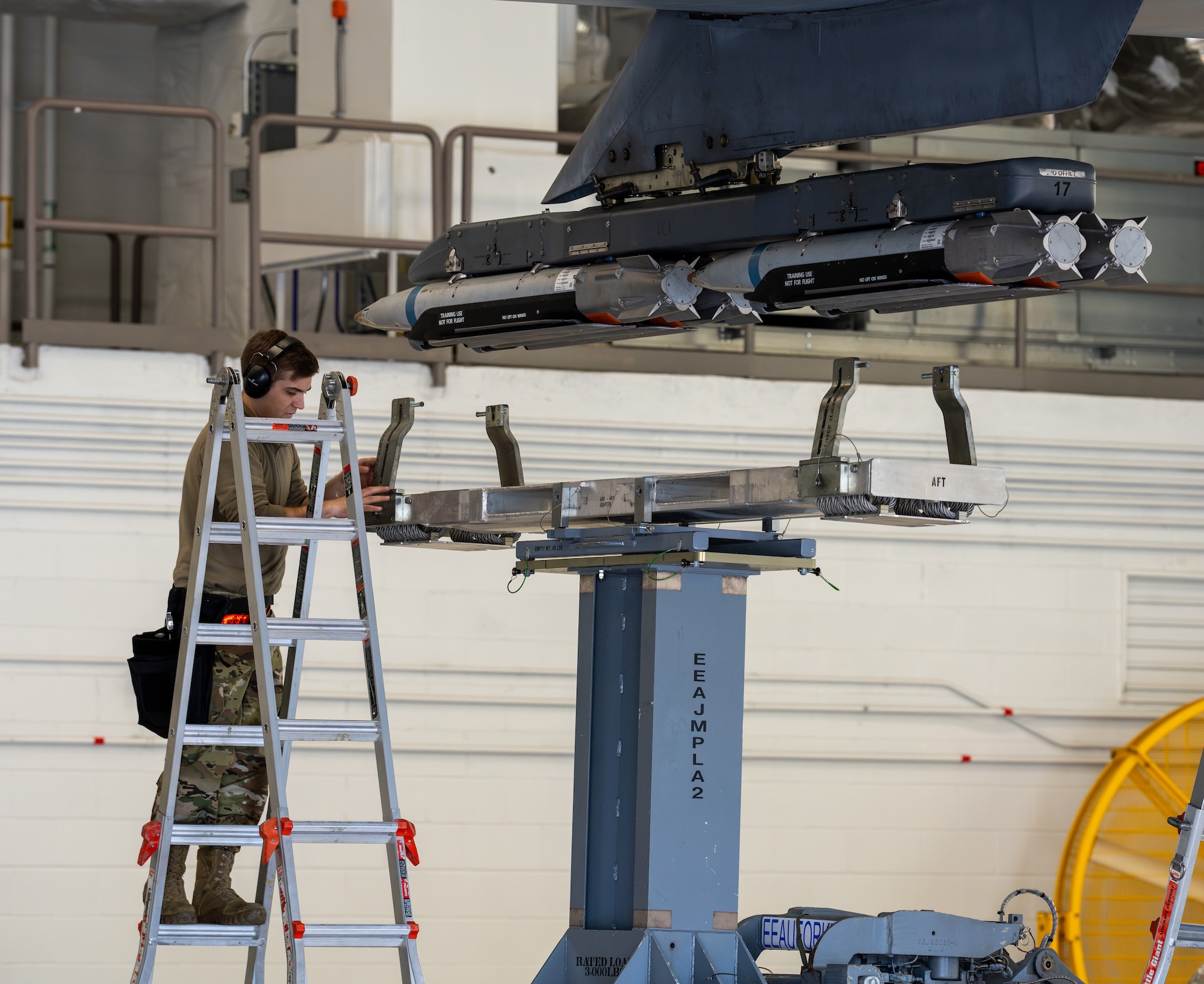 An Airman loads munitions on an aircraft.