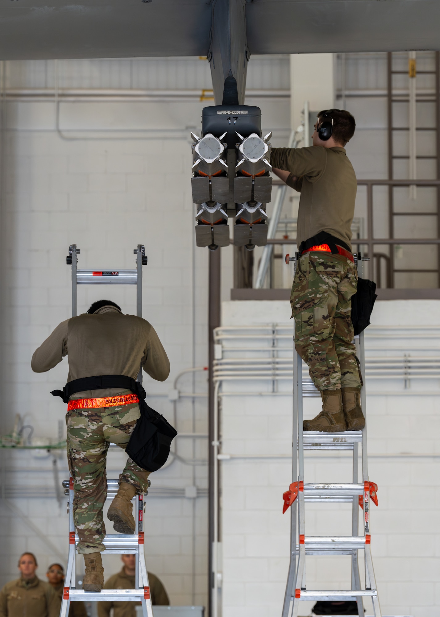 Airmen load munitions onto an aircraft.