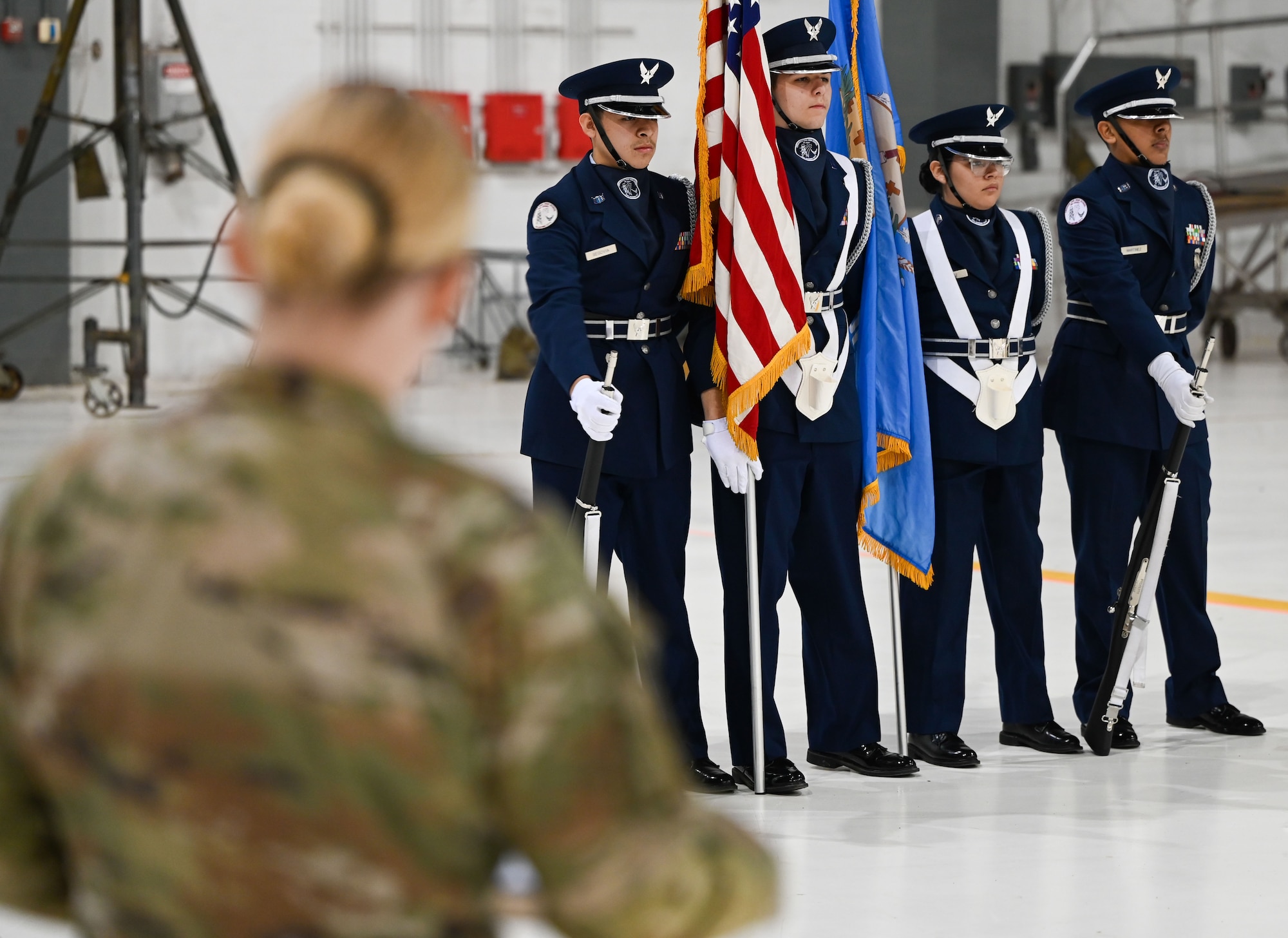 A judge evaluates a Junior Reserve Officers' Training Corps (JROTC) color guard team during the JROTC Drill Competition at Tinker Air Force Base; Oklahoma; Feb. 15; 2024. The competition; returning to base for the first time in more than 20 years; featured precision marching; color guard performances; and exhibition drills. (U.S. Air Force photo by Garrett N. Cole)
