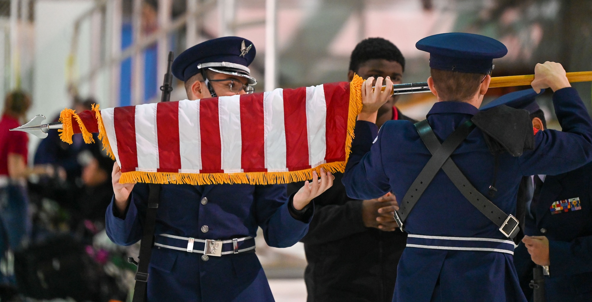 Junior Reserve Officers' Training Corps (JROTC) cadets carefully fold the U.S. flag following a color guard performance at the JROTC Drill Competition at Tinker Air Force Base, Oklahoma, Feb. 15, 2024. The event, returning to the base for the first time in more than 20 years, showcased cadets' discipline, precision, and teamwork. (U.S. Air Force photo by Garrett N. Cole)