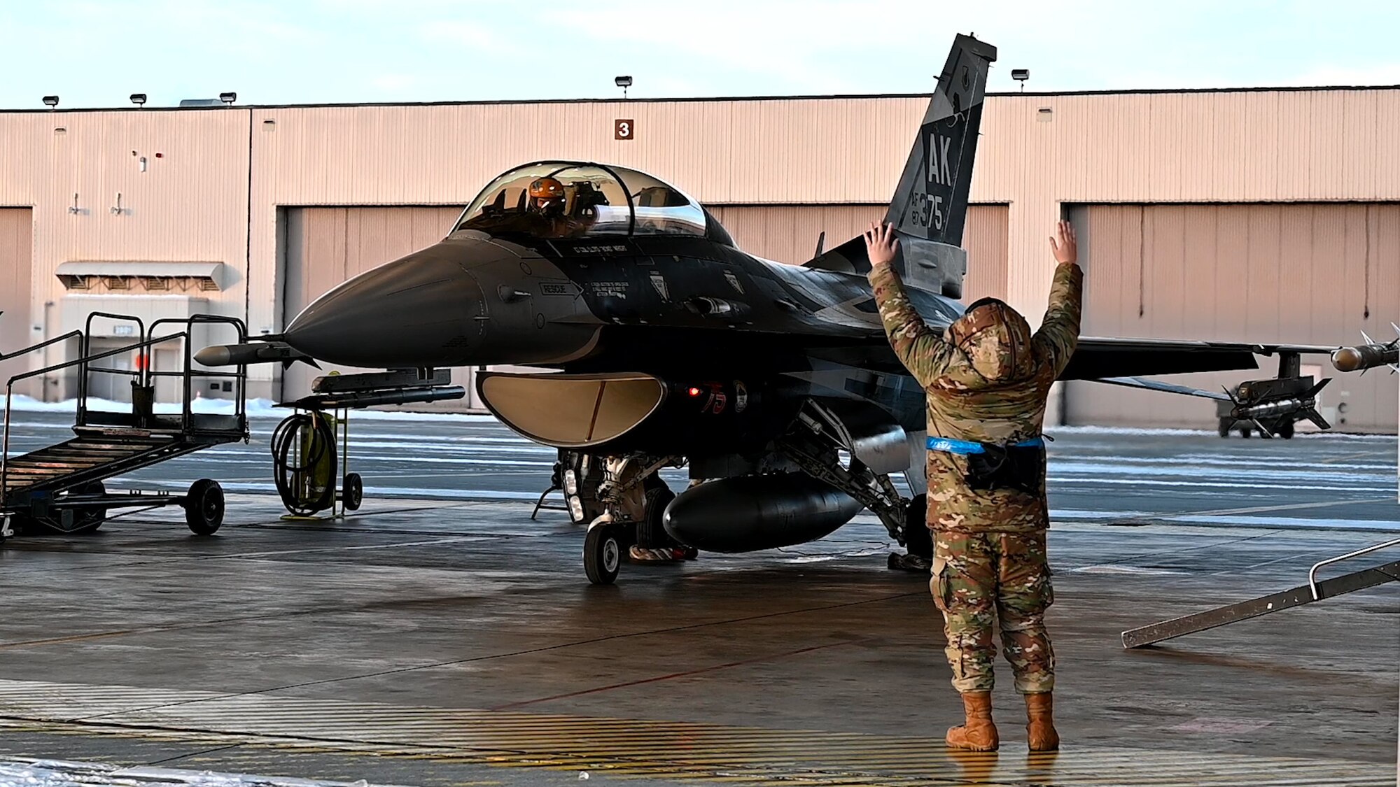 A U.S. Air Force Airman assigned to the 18th Fighter Generation Squadron marshals an F-16 Fighting Falcon assigned to the 18th Fighter Interceptor Squadron prior to takeoff at Eielson Air Force Base, Alaska