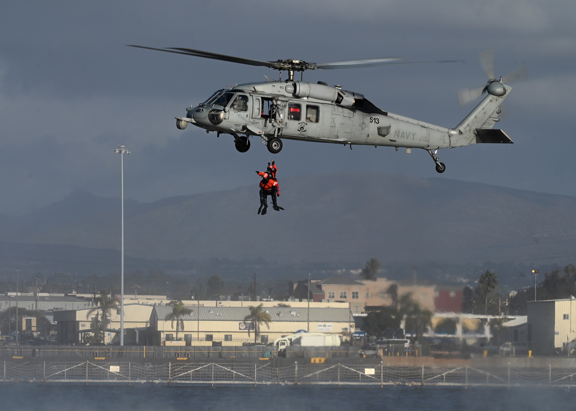 A U.S. Navy MH-60S SeaHawk helicopter assigned to the Helicopter Sea Combat Squadron 8 extracts two pararescue U.S. Airmen during Exercise Bamboo Eagle 25-1, from the San Diego Bay, California, on Feb. 14, 2025. The 414th Combat Training Squadron Detachment 1 created this scenario and played a pivotal role in preparing U.S. and allied air forces for intricate combat situations. (U.S. Air Force photo by Staff Sgt. Abbey Rieves)