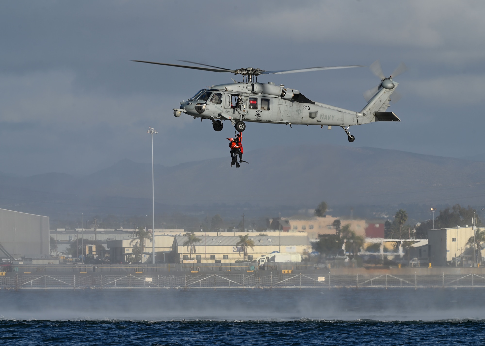 A U.S. Navy MH-60S SeaHawk helicopter assigned to the Helicopter Sea Combat Squadron 8 extracts two pararescue U.S. Airmen during Exercise Bamboo Eagle 25-1, from the San Diego Bay, California, on Feb. 14, 2025. The 414th Combat Training Squadron Detachment 1 created this scenario and played a pivotal role in preparing U.S. and allied air forces for intricate combat situations. (U.S. Air Force photo by Staff Sgt. Abbey Rieves)