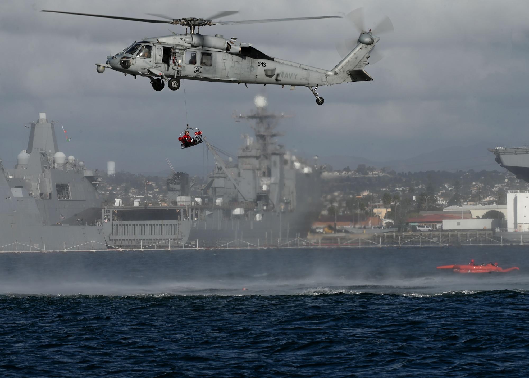 A U.S. Navy MH-60S SeaHawk helicopter assigned to the Helicopter Sea Combat Squadron 8 extracts an isolated U.S. Air Force Airman during Exercise Bamboo Eagle 25-1 in San Diego Bay, California, on Feb. 14, 2025. Rescue assets from both the Navy and Air Force worked together, showcasing their capabilities in joint force domination. (U.S. Air Force photo by Staff Sgt. Abbey Rieves)