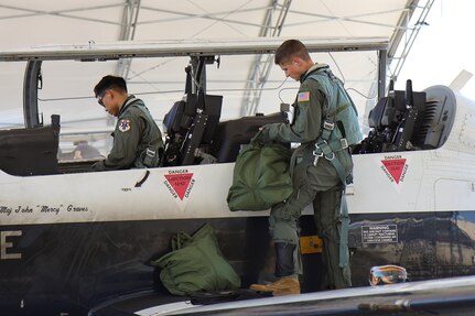 U.S. Air Force Lieutenant Col. Roy Calilung (left), 455th Flying Training Squadron combat systems operator instructor, and 2nd Lieutenant Claas McCrae (right), 455th FTS CSO student, conduct preflight checks on a T-6 Texan II March 6, 2025, at Naval Air Station Pensacola, Florida.