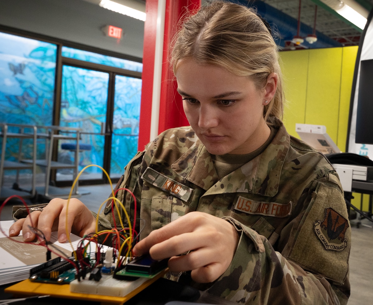 An Airman builds a prototype sensor using a circuit board.
