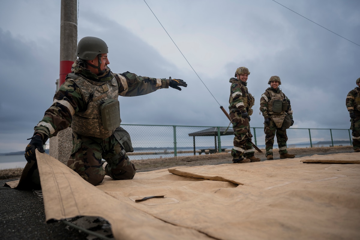 U.S. Air Force Senior Airman Nathanial Titus, 35th Fighter Wing Mission Ready Airman (MRA) program participant, instructs other participants on folding a tent cover during spoke teardown as part of the Beverly Sunrise 25-03 exercise at Misawa Air Base, Japan, March 18, 2025.